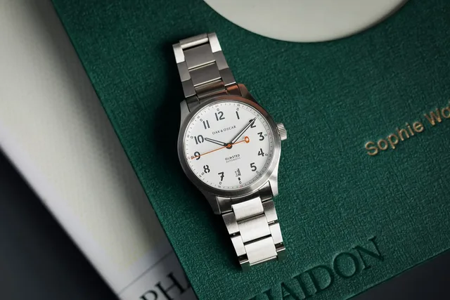 Oak-Oscar-Omsted-38-White-Steel-Bracelet-Overhead-On-Book_2100x1400