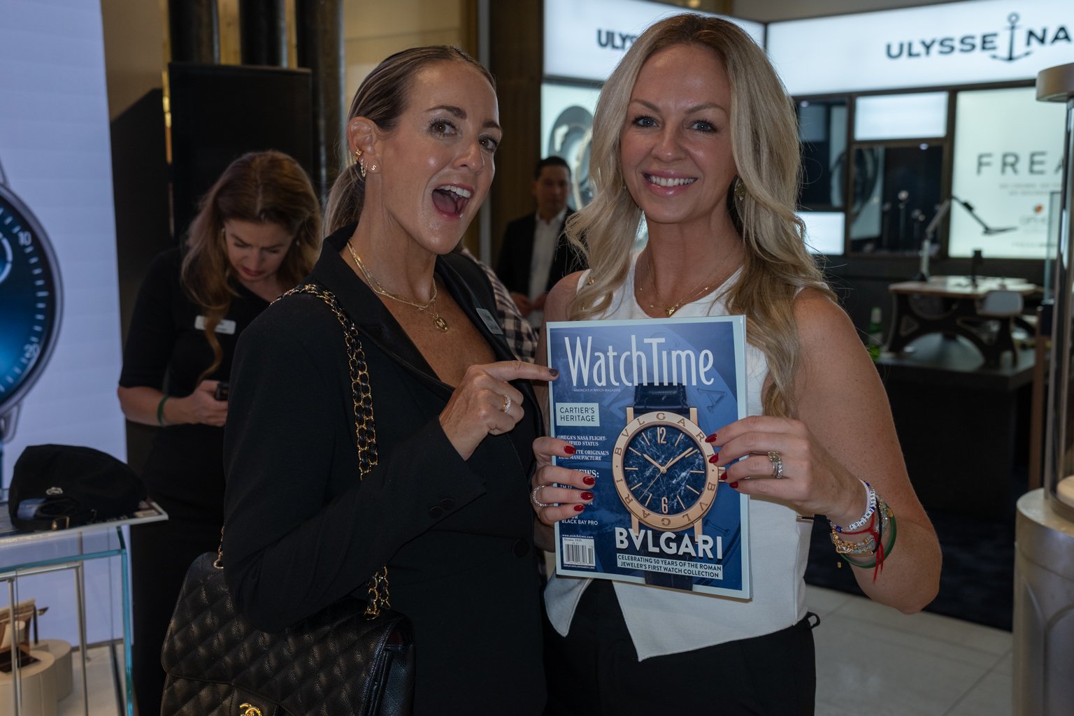 Two guests smile while holding an issue of WatchTime magazine at the 2025 WatchTime Chicago event at Burdeen’s Jewelry.